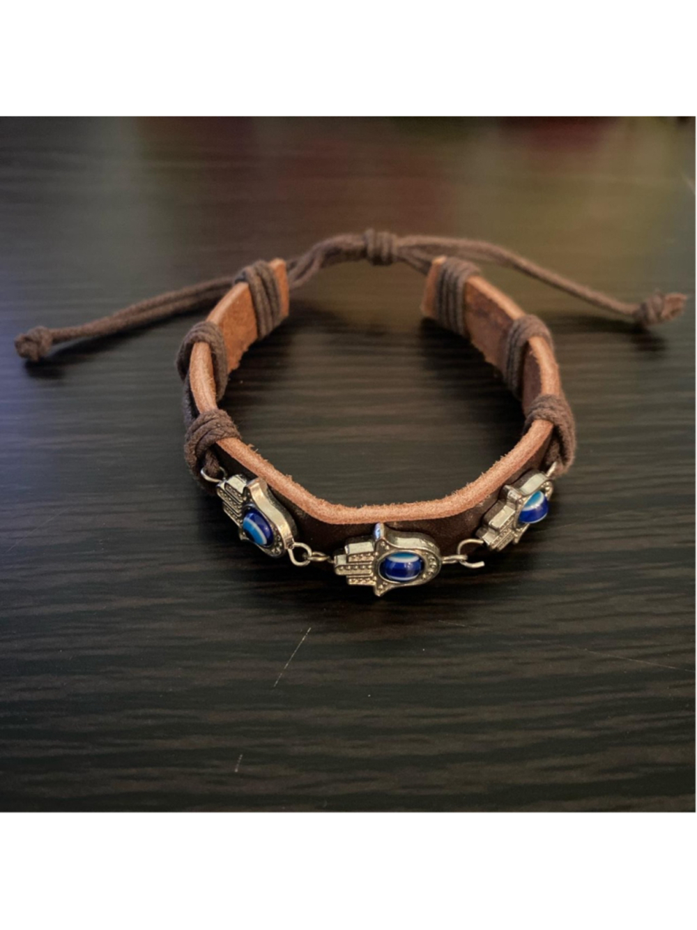 Brown leather bracelet with adjustable straps and silver hamsa charms with blue